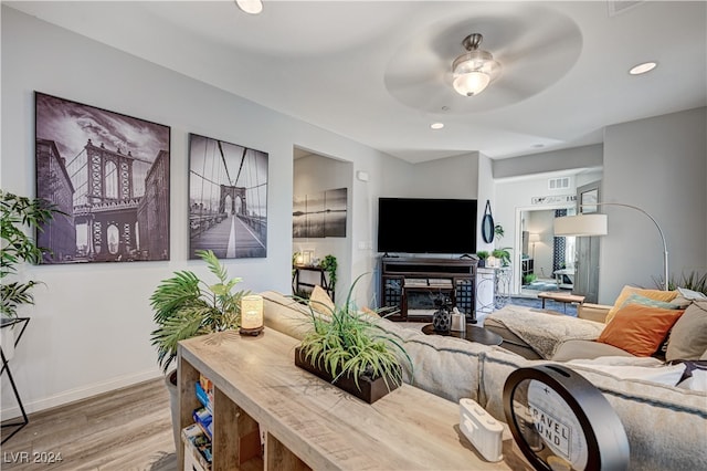 living room featuring light wood-type flooring and ceiling fan