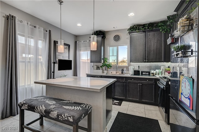 kitchen featuring tasteful backsplash, a kitchen bar, pendant lighting, black range oven, and a center island