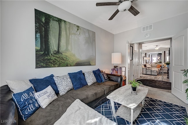 living room with ceiling fan and dark carpet