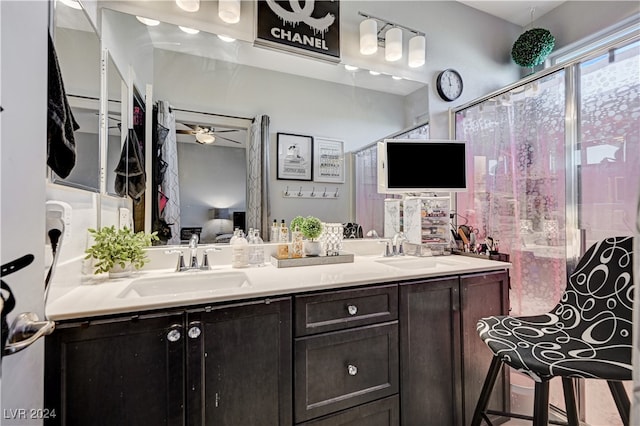 bathroom featuring ceiling fan, vanity, and a shower with door