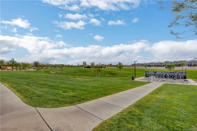 view of property's community with a yard and a patio area