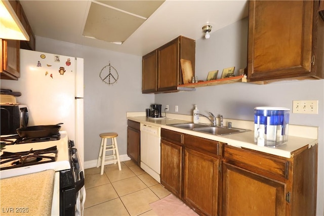 kitchen with light countertops, light tile patterned flooring, brown cabinetry, white dishwasher, and a sink