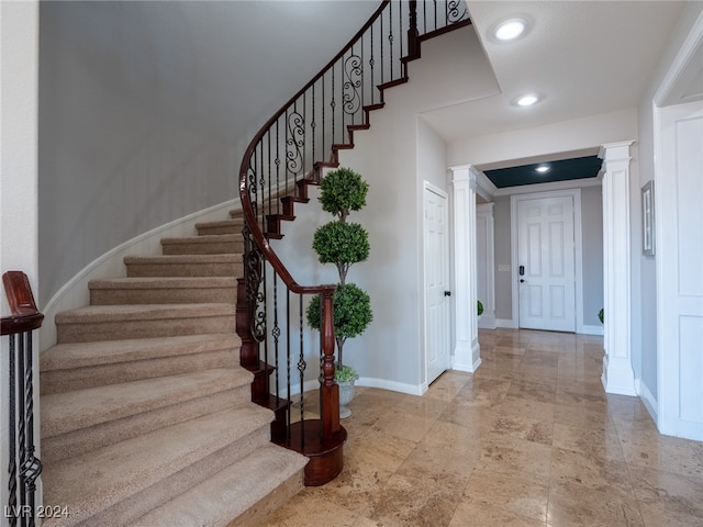 staircase featuring decorative columns