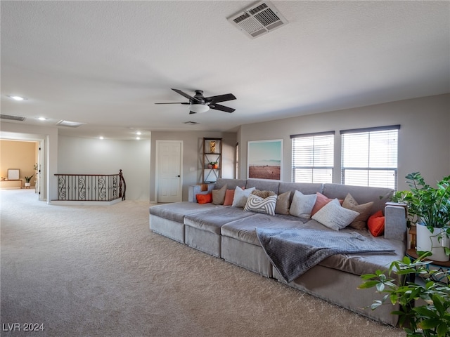 carpeted living room with ceiling fan