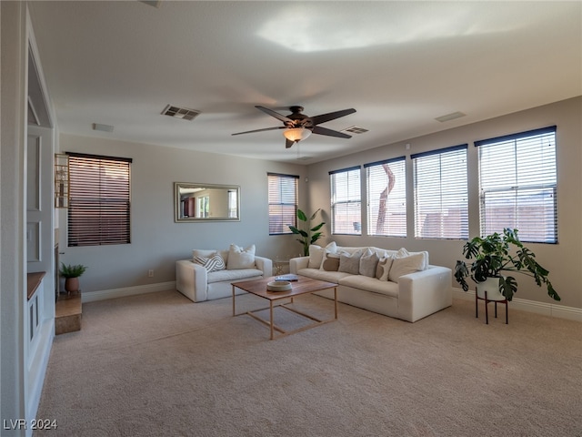 living room featuring ceiling fan, light colored carpet, and plenty of natural light