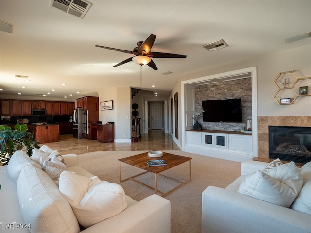 living room with ceiling fan, built in features, and a fireplace