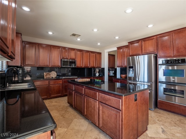 kitchen with tasteful backsplash, stainless steel appliances, a center island, and sink