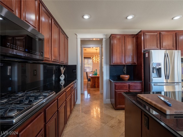 kitchen with appliances with stainless steel finishes, a chandelier, and decorative backsplash