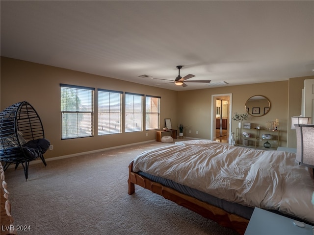 carpeted bedroom featuring ceiling fan and ensuite bath