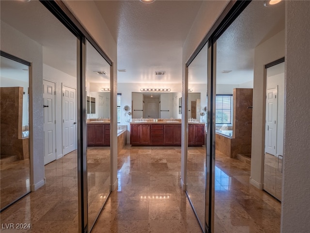 bathroom with vanity, a textured ceiling, and plus walk in shower