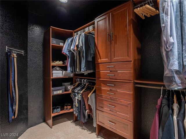 walk in closet featuring light carpet