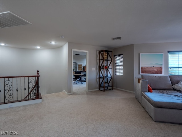 unfurnished living room featuring light colored carpet and plenty of natural light