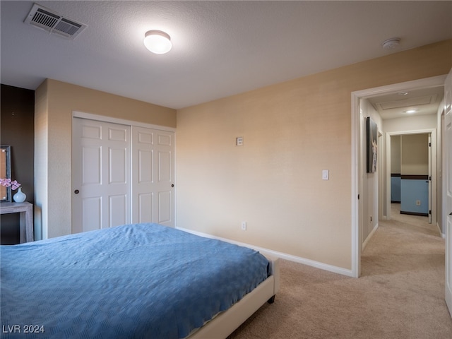 bedroom with light colored carpet and a closet