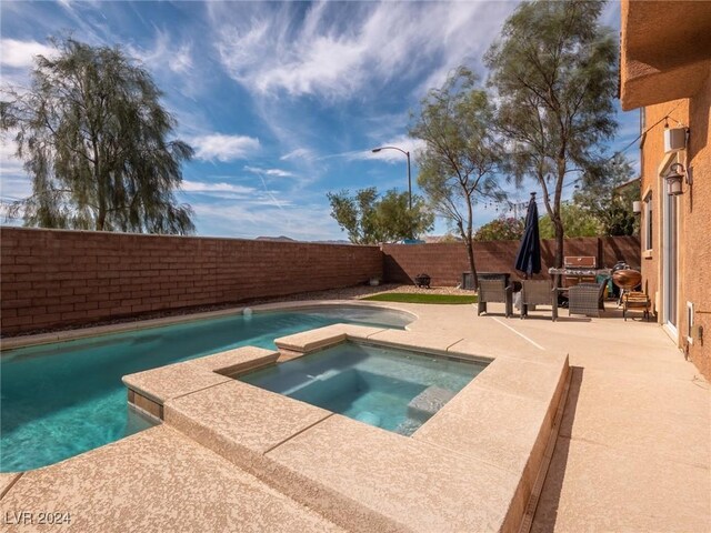 view of swimming pool featuring an in ground hot tub and a patio area