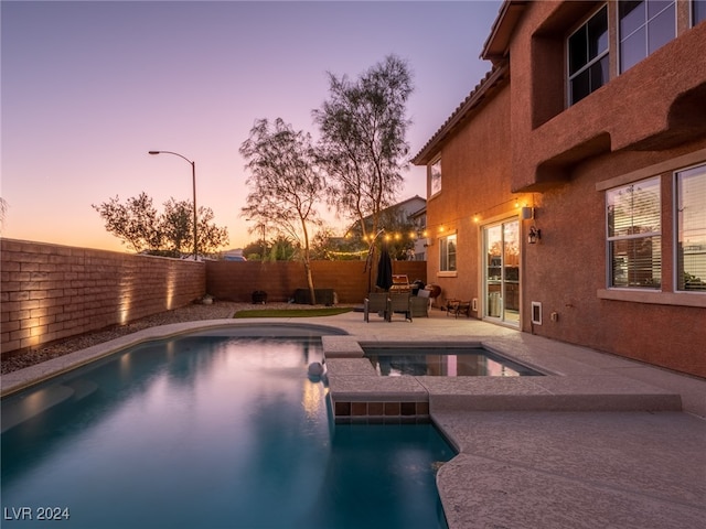 pool at dusk featuring a patio area