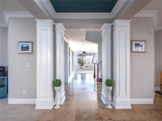 hall featuring ornamental molding and decorative columns