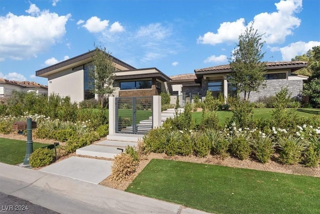 view of front of home featuring a front yard, a gate, and stucco siding