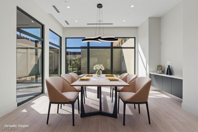 dining room with light hardwood / wood-style flooring and a notable chandelier