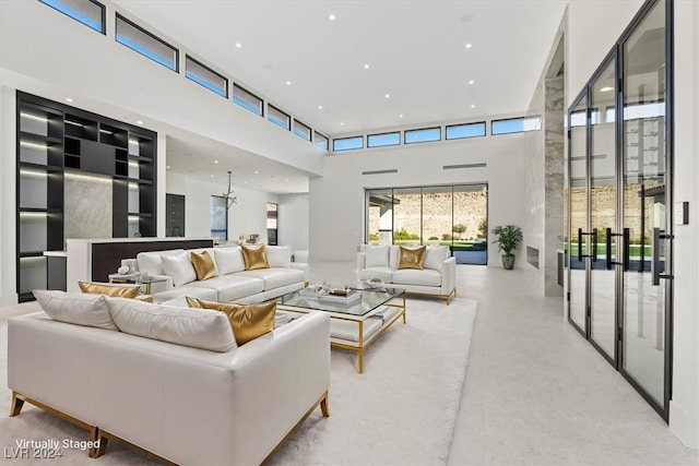 living area with recessed lighting, concrete flooring, and a high ceiling