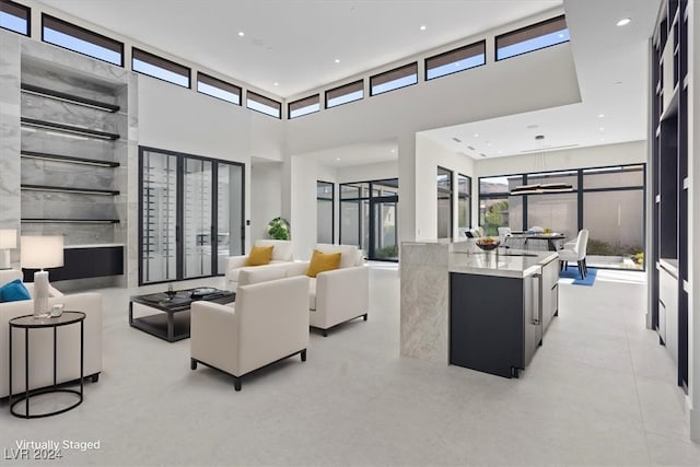 living room with recessed lighting and a towering ceiling