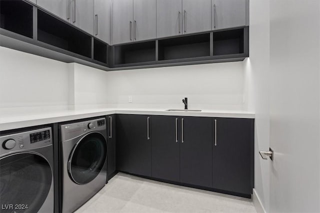 laundry area featuring washer and dryer, cabinet space, and a sink