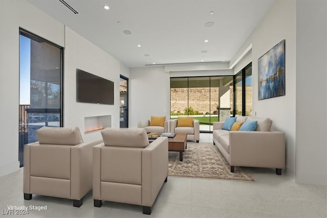 living area with recessed lighting and a lit fireplace