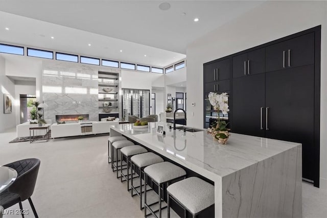 1 Olympia Canyon Way, Las Vegas, NV 89141 - kitchen with dark cabinets, a sink, open floor plan, a spacious island, and recessed lighting