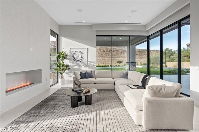 1 Olympia Canyon Way, Las Vegas, NV 89141 - living area featuring a glass covered fireplace, healthy amount of natural light, and recessed lighting