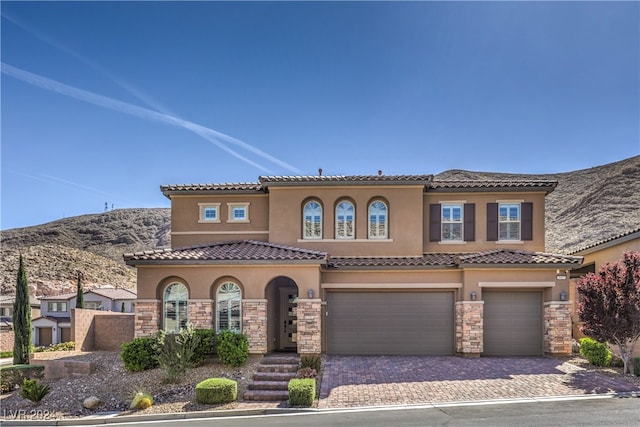 mediterranean / spanish home with a mountain view and a garage