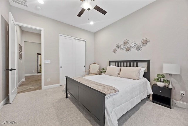 bedroom featuring ceiling fan, a closet, and light parquet flooring