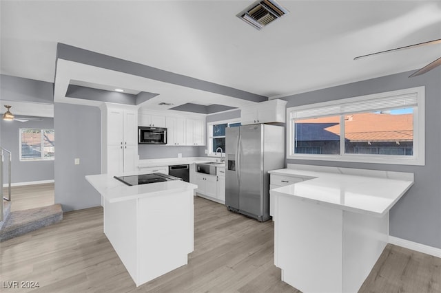 kitchen featuring white cabinets, light hardwood / wood-style floors, and black appliances