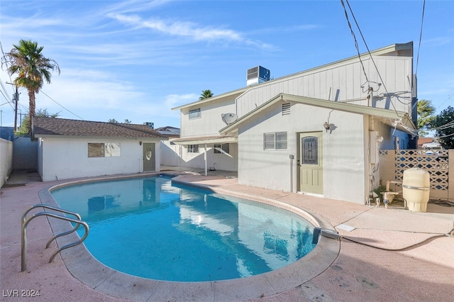 view of pool with central air condition unit and a patio