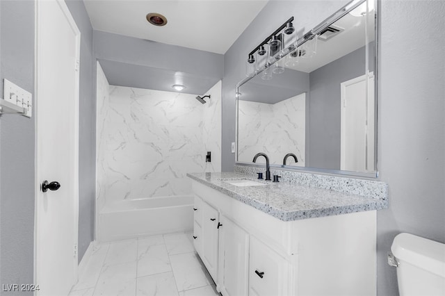 full bathroom with vanity, tiled shower / bath combo, and toilet