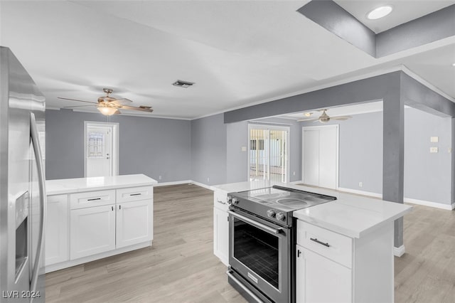 kitchen with stainless steel appliances, light hardwood / wood-style floors, and white cabinetry