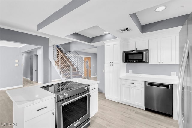 kitchen featuring white cabinetry, light stone countertops, light hardwood / wood-style floors, and stainless steel appliances