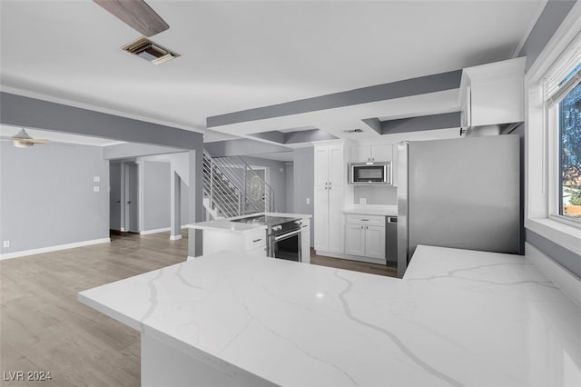 kitchen featuring light stone countertops, white cabinets, light hardwood / wood-style floors, and stainless steel appliances