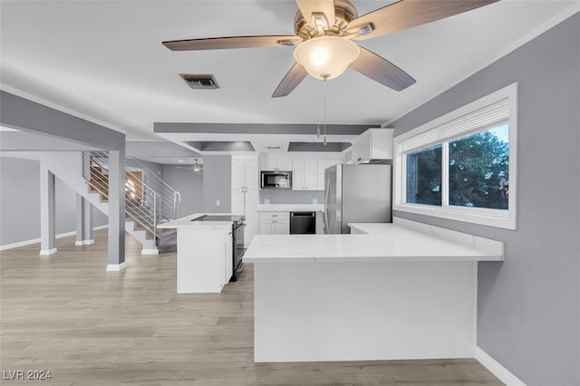 kitchen with light hardwood / wood-style flooring, white cabinetry, kitchen peninsula, and stainless steel appliances