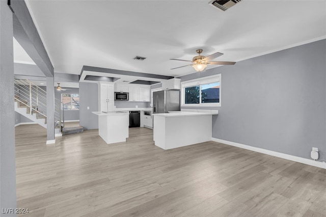 kitchen with kitchen peninsula, light hardwood / wood-style flooring, ornamental molding, white cabinetry, and appliances with stainless steel finishes