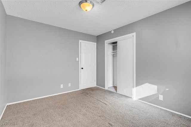 unfurnished bedroom featuring carpet flooring, a textured ceiling, and a closet