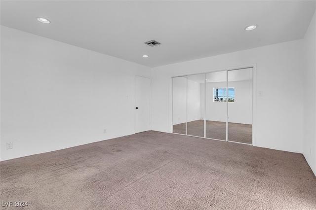 unfurnished bedroom with a closet and carpet floors