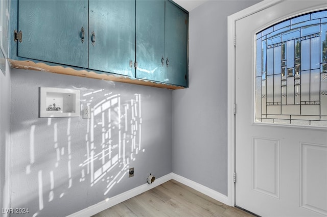 washroom with electric dryer hookup, hookup for a washing machine, cabinets, and light hardwood / wood-style floors