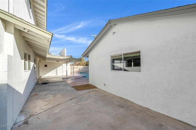 view of home's exterior with a balcony and a patio