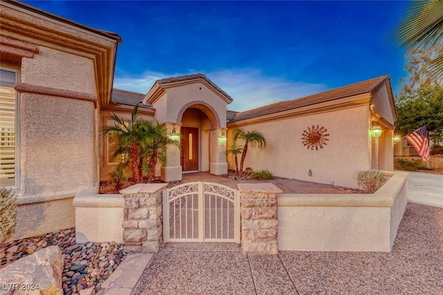 view of front of house with a gate and stucco siding