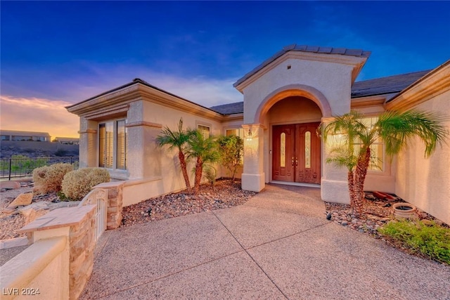 exterior entry at dusk with stucco siding