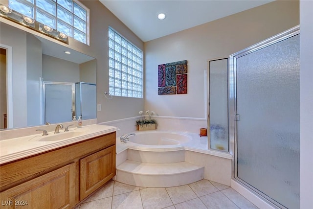 bathroom with a bath, a shower stall, tile patterned flooring, and vanity