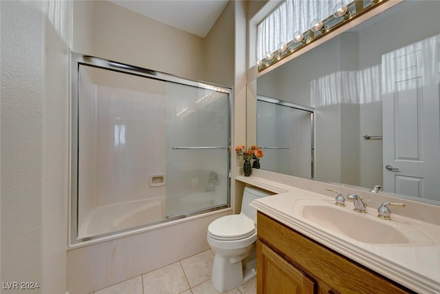 bathroom featuring combined bath / shower with glass door, vanity, toilet, and tile patterned floors