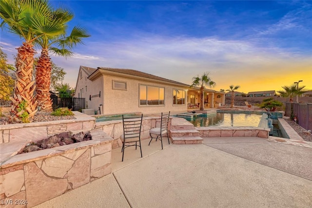 exterior space featuring a fenced in pool, a patio, a jacuzzi, fence, and stucco siding