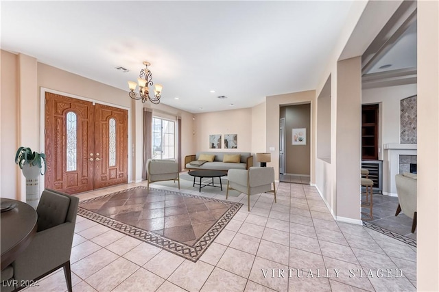 entrance foyer featuring light tile patterned floors, baseboards, wine cooler, a fireplace, and a chandelier