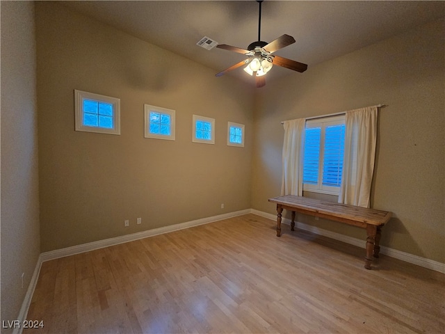 empty room featuring ceiling fan, plenty of natural light, light hardwood / wood-style flooring, and lofted ceiling