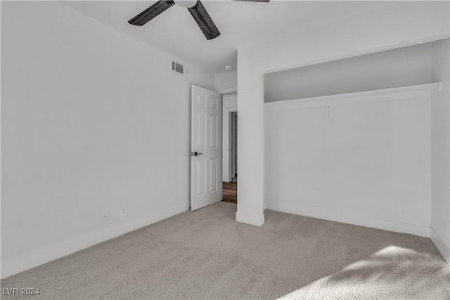 unfurnished bedroom featuring light carpet, a closet, and ceiling fan